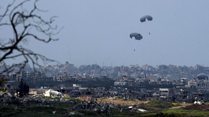 An aircraft airdrops humanitarian aid over the northern Gaza Strip, as seen from southern Israel, Sunday, March 24, 2024. (AP Photo/Tsafrir Abayov)