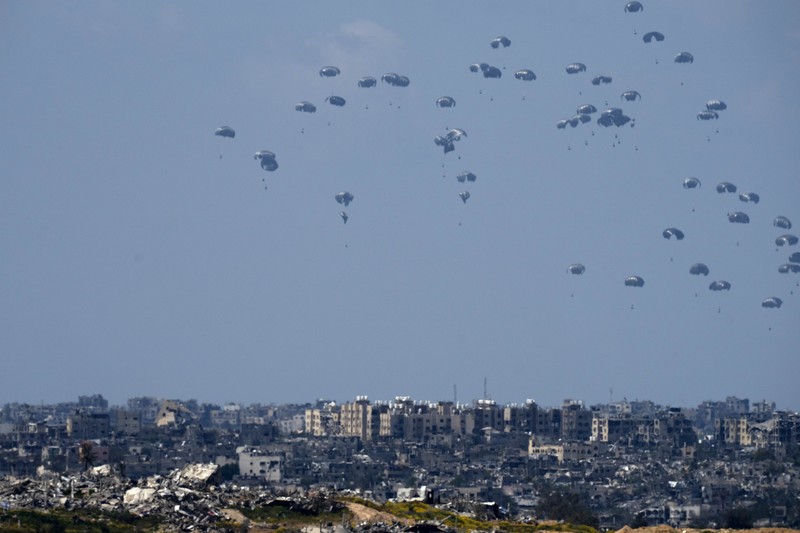 APTOPIX Israel Palestinians An aircraft airdrops humanitarian aid over the northern Gaza Strip, as seen from southern Israel, Sunday, March 24, 2024. (AP Photo/Tsafrir Abayov)