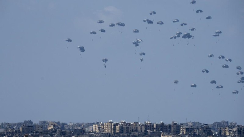 An aircraft airdrops humanitarian aid over the northern Gaza Strip, as seen from southern Israel, Sunday, March 24, 2024. (AP Photo/Tsafrir Abayov)