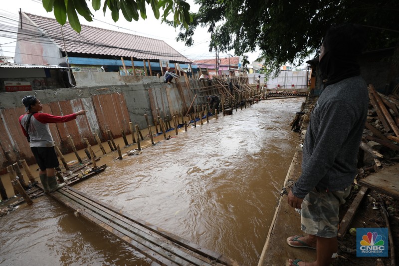 Petugas Penanganan Prasarana dan Sarana Umum (PPSU) membersihkan sisa-sisa sampah di proyek tanggul kali Hek kawasan Kramat Jati jati, Jakarta, Senin (25/3/2024). Petugas Penanganan Prasarana dan Sarana Umum (PPSU) membersihkan sisa-sisa sampah di proyek tanggul kali Hek kawasan Kramat Jati jati, Jakarta, Senin (25/3/2024). (CNBC Indonesia/Tri Susilo)