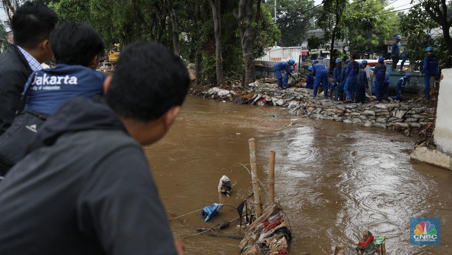 Petugas Penanganan Prasarana dan Sarana Umum (PPSU) membersihkan sisa-sisa sampah di proyek tanggul kali Hek kawasan Kramat Jati jati, Jakarta, Senin (25/3/2024). (²©²ÊÍøÕ¾/Tri Susilo)