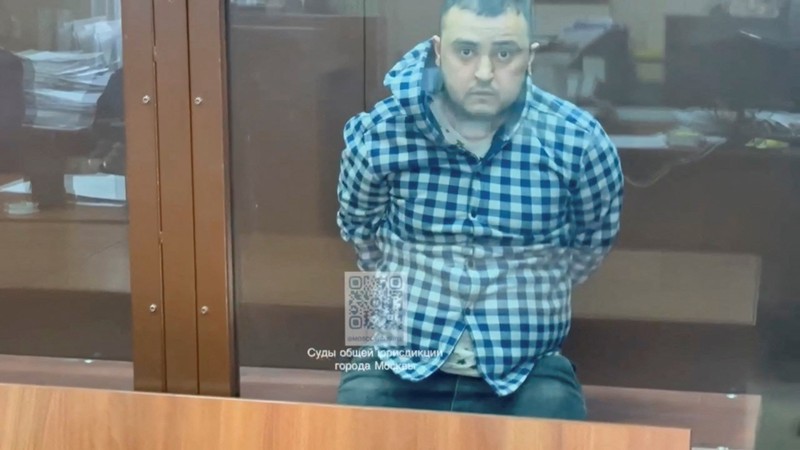 Seorang tersangka penembakan Balai Kota Crocus dikawal dari sebuah van ke markas besar Komite Investigasi Rusia di Moskow, Rusia, dalam gambar diam yang diambil dari video yang dirilis 24 Maret 2024. (Russian Investigative Committee/Handout via REUTERS)