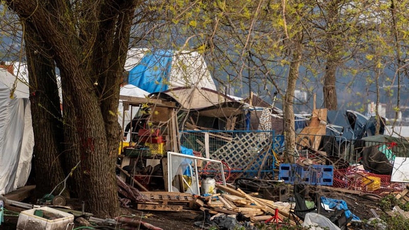 Vancouver Park Rangers memasang pagar untuk menampung area saat Kota Vancouver merencanakan pembersihan Taman Kepiting tepi laut tempat para tunawisma berkemah selama tiga tahun, di Vancouver, British Columbia, Kanada 25 Maret 2024. (REUTERS/Paige Taylor White)