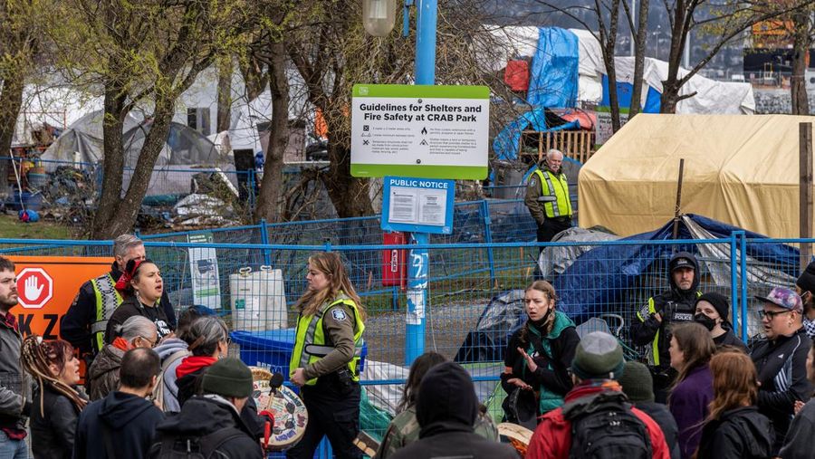 Vancouver Park Rangers memasang pagar untuk menampung area saat Kota Vancouver merencanakan pembersihan Taman Kepiting tepi laut tempat para tunawisma berkemah selama tiga tahun, di Vancouver, British Columbia, Kanada 25 Maret 2024. (REUTERS/Paige Taylor White)