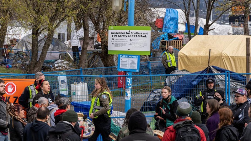 Vancouver Park Rangers memasang pagar untuk menampung area saat Kota Vancouver merencanakan pembersihan Taman Kepiting tepi laut tempat para tunawisma berkemah selama tiga tahun, di Vancouver, British Columbia, Kanada 25 Maret 2024. (REUTERS/Paige Taylor White)