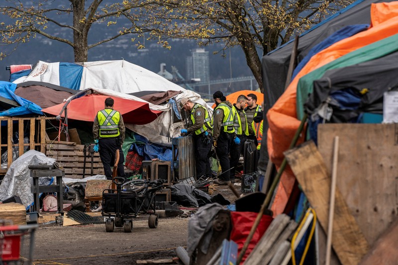 Vancouver Park Rangers memasang pagar untuk menampung area saat Kota Vancouver merencanakan pembersihan Taman Kepiting tepi laut tempat para tunawisma berkemah selama tiga tahun, di Vancouver, British Columbia, Kanada 25 Maret 2024. (REUTERS/Paige Taylor White)