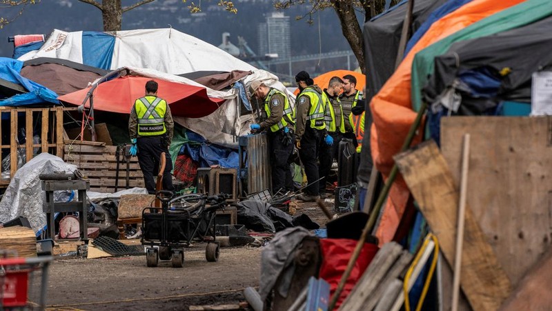 Vancouver Park Rangers memasang pagar untuk menampung area saat Kota Vancouver merencanakan pembersihan Taman Kepiting tepi laut tempat para tunawisma berkemah selama tiga tahun, di Vancouver, British Columbia, Kanada 25 Maret 2024. (REUTERS/Paige Taylor White)