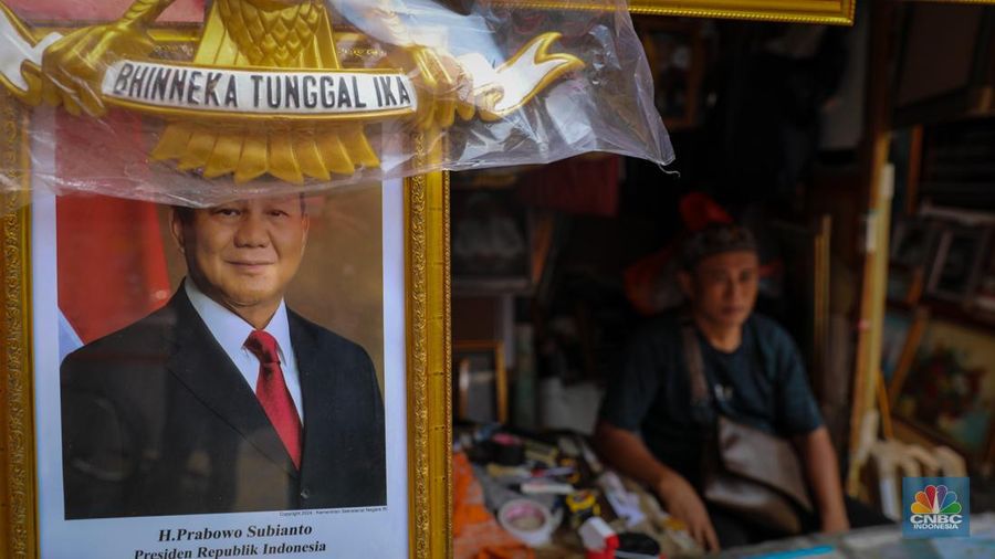 Penjual menata poster dengan foto pasangan Capres-Cawapres nomor urut 02, Prabowo Subianto dan Gibran Rakabuming Raka yang dijual pada kiosnya di kawasan Pasar Baru, Jakarta, Selasa (26/3/2024). (CNBC Indonesia/Faisal Rahman)