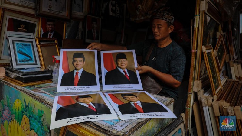Penjual menata poster dengan foto pasangan Capres-Cawapres nomor urut 02, Prabowo Subianto dan Gibran Rakabuming Raka yang dijual pada kiosnya di kawasan Pasar Baru, Jakarta, Selasa (26/3/2024). (CNBC Indonesia/Faisal Rahman)