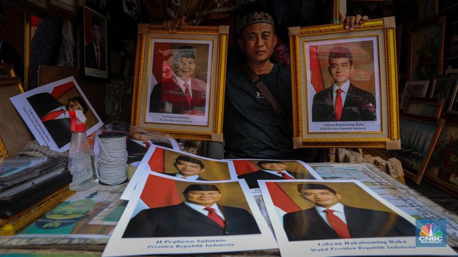 Penjual menata poster dengan foto pasangan Capres-Cawapres nomor urut 02, Prabowo Subianto dan Gibran Rakabuming Raka yang dijual pada kiosnya di kawasan Pasar Baru, Jakarta, Selasa (26/3/2024). (CNBC Indonesia/Faisal Rahman)