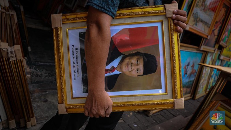 Penjual menata poster dengan foto pasangan Capres-Cawapres nomor urut 02, Prabowo Subianto dan Gibran Rakabuming Raka yang dijual pada kiosnya di kawasan Pasar Baru, Jakarta, Selasa (26/3/2024). (CNBC Indonesia/Faisal Rahman)