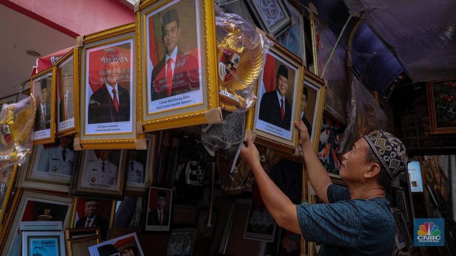 Penjual menata poster dengan foto pasangan Capres-Cawapres nomor urut 02, Prabowo Subianto dan Gibran Rakabuming Raka yang dijual pada kiosnya di kawasan Pasar Baru, Jakarta, Selasa (26/3/2024). (CNBC Indonesia/Faisal Rahman)