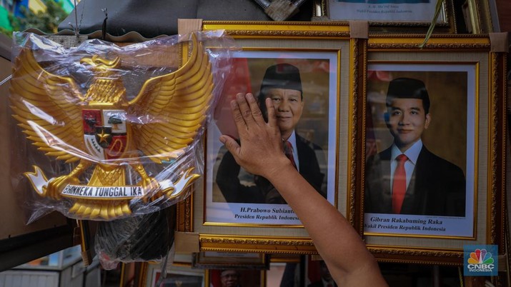 Penjual menata poster dengan foto pasangan Capres-Cawapres nomor urut 02, Prabowo Subianto dan Gibran Rakabuming Raka yang dijual pada kiosnya di kawasan Pasar Baru, Jakarta, Selasa (26/3/2024). (CNBC Indonesia/Faisal Rahman)