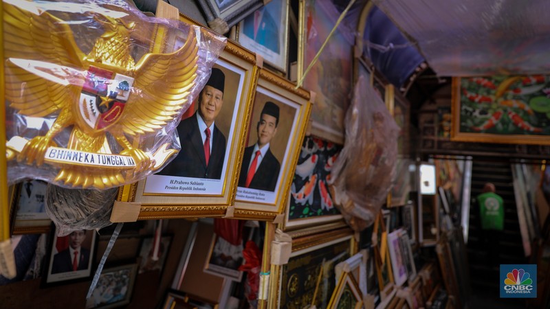 Penjual menata poster dengan foto pasangan Capres-Cawapres nomor urut 02, Prabowo Subianto dan Gibran Rakabuming Raka yang dijual pada kiosnya di kawasan Pasar Baru, Jakarta, Selasa (26/3/2024). (CNBC Indonesia/Faisal Rahman)