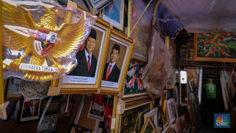 Penjual menata poster dengan foto pasangan Capres-Cawapres nomor urut 02, Prabowo Subianto dan Gibran Rakabuming Raka yang dijual pada kiosnya di kawasan Pasar Baru, Jakarta, Selasa (26/3/2024). (CNBC Indonesia/Faisal Rahman)