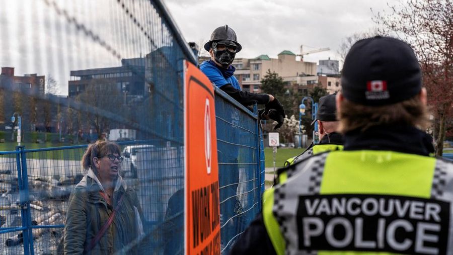 Vancouver Park Rangers memasang pagar untuk menampung area saat Kota Vancouver merencanakan pembersihan Taman Kepiting tepi laut tempat para tunawisma berkemah selama tiga tahun, di Vancouver, British Columbia, Kanada 25 Maret 2024. (REUTERS/Paige Taylor White)