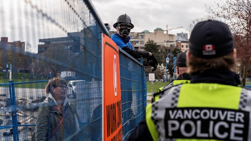 Vancouver Park Rangers memasang pagar untuk menampung area saat Kota Vancouver merencanakan pembersihan Taman Kepiting tepi laut tempat para tunawisma berkemah selama tiga tahun, di Vancouver, British Columbia, Kanada 25 Maret 2024. (REUTERS/Paige Taylor White)