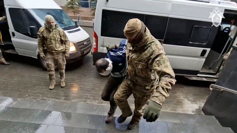 Seorang tersangka penembakan Balai Kota Crocus dikawal dari sebuah van ke markas besar Komite Investigasi Rusia di Moskow, Rusia, dalam gambar diam yang diambil dari video yang dirilis 24 Maret 2024. (Russian Investigative Committee/Handout via REUTERS)