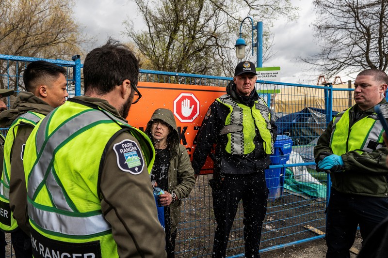 Vancouver Park Rangers memasang pagar untuk menampung area saat Kota Vancouver merencanakan pembersihan Taman Kepiting tepi laut tempat para tunawisma berkemah selama tiga tahun, di Vancouver, British Columbia, Kanada 25 Maret 2024. (REUTERS/Paige Taylor White)