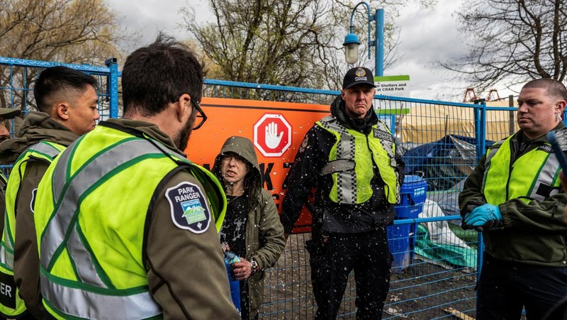 Vancouver Park Rangers memasang pagar untuk menampung area saat Kota Vancouver merencanakan pembersihan Taman Kepiting tepi laut tempat para tunawisma berkemah selama tiga tahun, di Vancouver, British Columbia, Kanada 25 Maret 2024. (REUTERS/Paige Taylor White)