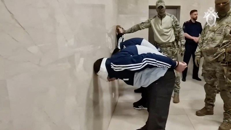 Seorang tersangka penembakan Balai Kota Crocus dikawal dari sebuah van ke markas besar Komite Investigasi Rusia di Moskow, Rusia, dalam gambar diam yang diambil dari video yang dirilis 24 Maret 2024. (Russian Investigative Committee/Handout via REUTERS)