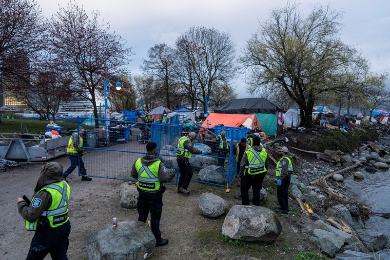 Vancouver Park Rangers memasang pagar untuk menampung area saat Kota Vancouver merencanakan pembersihan Taman Kepiting tepi laut tempat para tunawisma berkemah selama tiga tahun, di Vancouver, British Columbia, Kanada 25 Maret 2024. (REUTERS/Paige Taylor White)