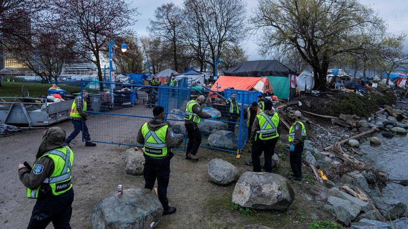 Vancouver Park Rangers memasang pagar untuk menampung area saat Kota Vancouver merencanakan pembersihan Taman Kepiting tepi laut tempat para tunawisma berkemah selama tiga tahun, di Vancouver, British Columbia, Kanada 25 Maret 2024. (REUTERS/Paige Taylor White)