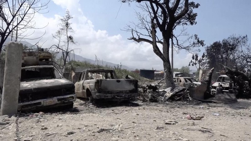 Seorang pria bereaksi di samping sisa-sisa kendaraan yang hangus di dekat istana presiden, setelah dibakar oleh geng, ketika kekerasan menyebar dan geng bersenjata memperluas kendali mereka atas ibu kota, di Port-au-Prince, Haiti, 25 Maret 2024. (REUTERS/Ralph Tedy Erol)