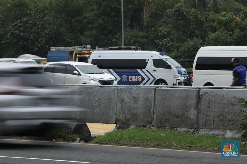 Petugas kepolisian melakukan olah Tempat Kejadian Perkara (TKP) di gerbang Pintu Tol Halim Utama, Jakarta, Rabu (27/3/2024). (CNBC Indonesia/Tri Susilo)