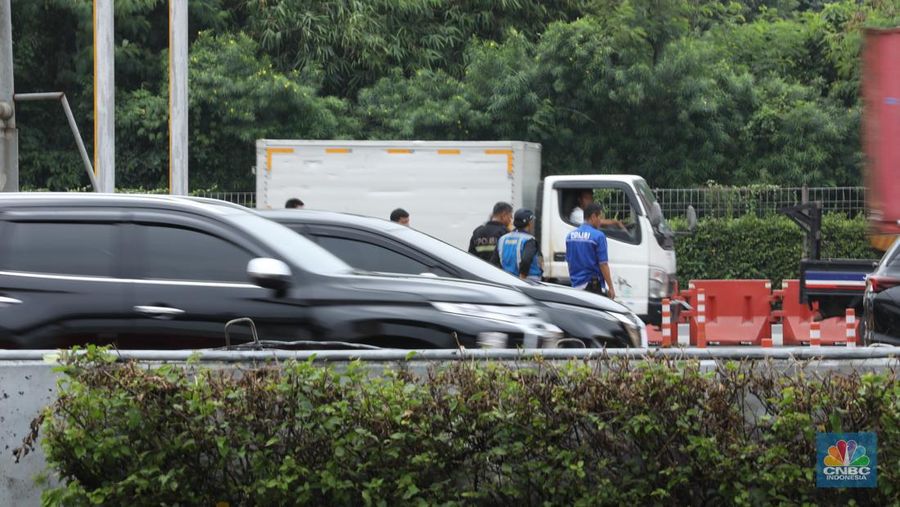 Petugas kepolisian melakukan olah Tempat Kejadian Perkara (TKP) di gerbang Pintu Tol Halim Utama, Jakarta, Rabu (27/3/2024). (CNBC Indonesia/Tri Susilo)