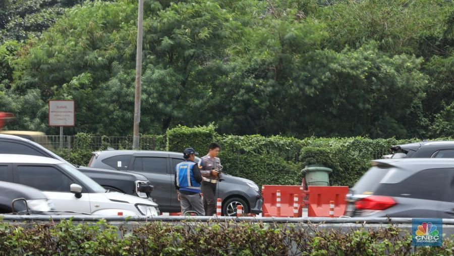 Petugas kepolisian melakukan olah Tempat Kejadian Perkara (TKP) di gerbang Pintu Tol Halim Utama, Jakarta, Rabu (27/3/2024). (CNBC Indonesia/Tri Susilo)