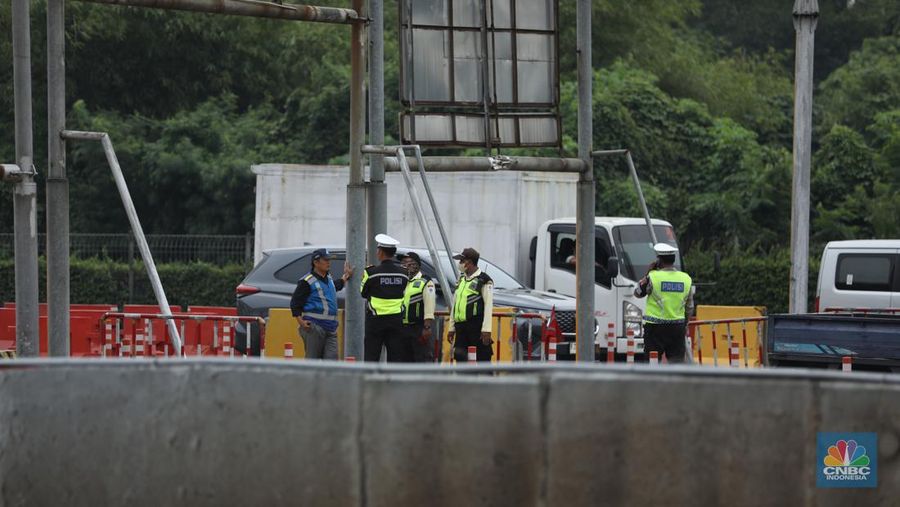 Petugas kepolisian melakukan olah Tempat Kejadian Perkara (TKP) di gerbang Pintu Tol Halim Utama, Jakarta, Rabu (27/3/2024). (CNBC Indonesia/Tri Susilo)