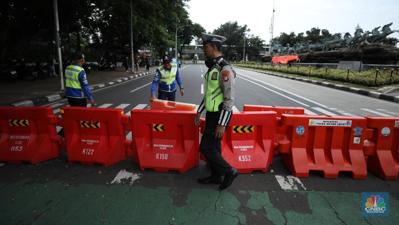 Petugas memindahkan pagar beton dengan alat berat di Kawasan Patung Kuda, Jakarta, Rabu (27/3/2024). (CNBC Indonesia/Tri Susilo)