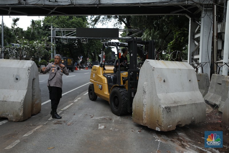 Petugas memindahkan pagar beton dengan alat berat di Kawasan Patung Kuda, Jakarta, Rabu (27/3/2024). (CNBC Indonesia/Tri Susilo)
