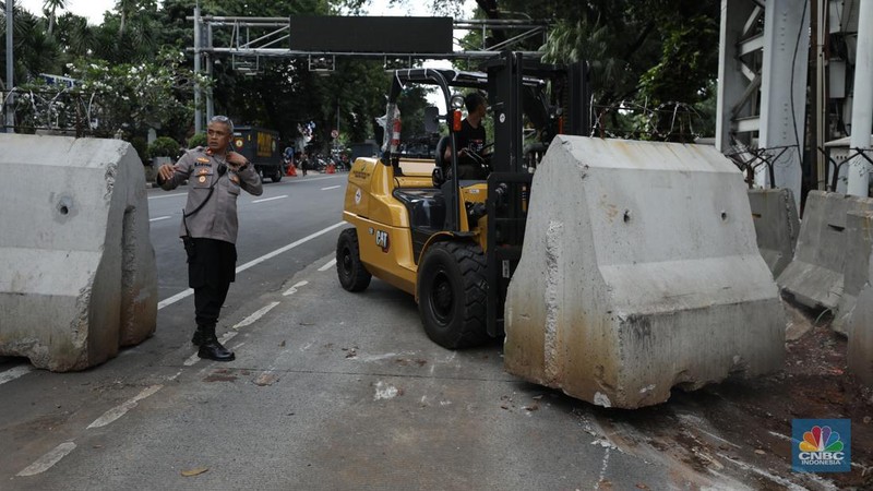 Petugas memindahkan pagar beton dengan alat berat di Kawasan Patung Kuda, Jakarta, Rabu (27/3/2024). (CNBC Indonesia/Tri Susilo)
