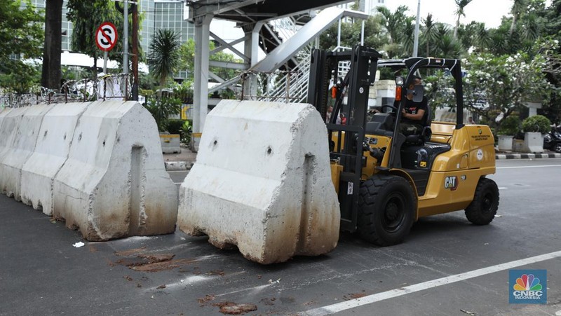 Petugas memindahkan pagar beton dengan alat berat di Kawasan Patung Kuda, Jakarta, Rabu (27/3/2024). (CNBC Indonesia/Tri Susilo)