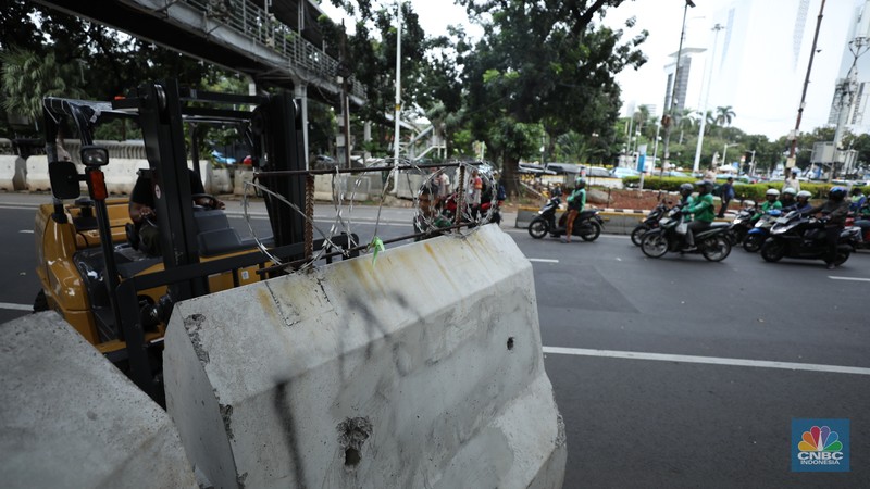 Petugas memindahkan pagar beton dengan alat berat di Kawasan Patung Kuda, Jakarta, Rabu (27/3/2024). (CNBC Indonesia/Tri Susilo)