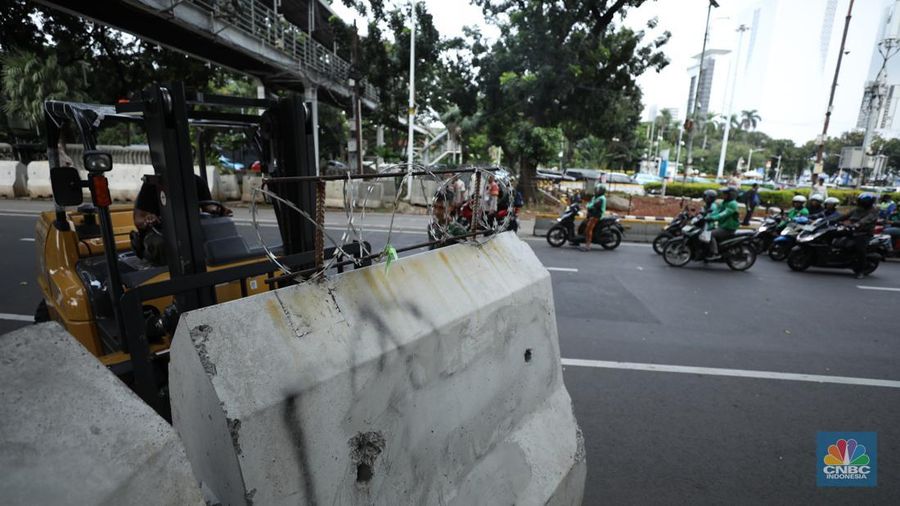 Petugas memindahkan pagar beton dengan alat berat di Kawasan Patung Kuda, Jakarta, Rabu (27/3/2024). (CNBC Indonesia/Tri Susilo)