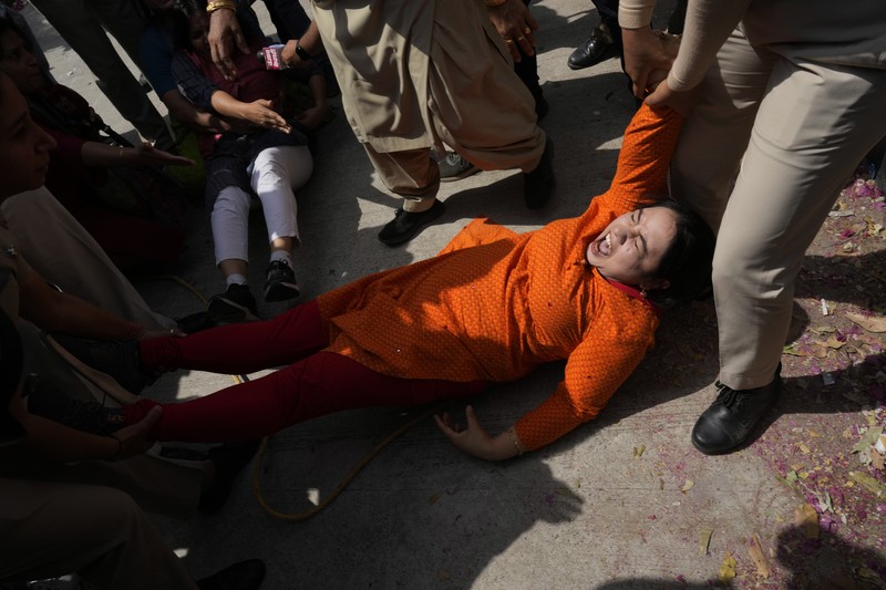 Polisi menahan anggota Partai Aam Admi, atau Partai Rakyat Biasa, saat protes terhadap penangkapan pemimpin partai mereka Arvind Kejriwal di New Delhi, India, Selasa, 26 Maret 2024. Polisi India telah menahan puluhan pengunjuk rasa oposisi dan mencegah mereka mulai dari melakukan unjuk rasa ke kediaman Perdana Menteri Narendra Modi untuk menuntut pembebasan pemimpin mereka dan pejabat tinggi terpilih di New Delhi yang ditangkap pekan lalu dalam kasus suap minuman keras. (AP Photo/Manish Swarup)
