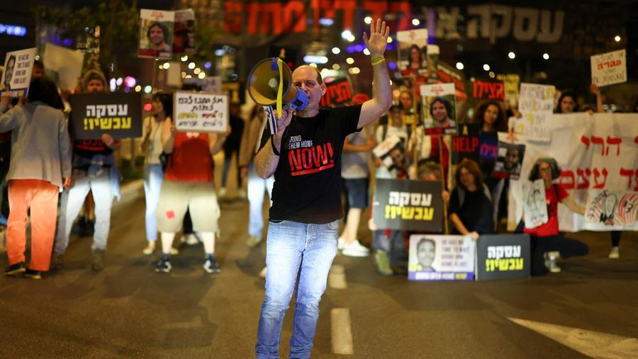 Demonstran menunjukkan tanda-tanda di tengah lalu lintas pada protes menuntut pembebasan sandera yang diculik dalam serangan mematikan 7 Oktober di Israel oleh kelompok Islam Palestina Hamas dari Gaza, di Tel Aviv, Israel 27 Maret 2024. (REUTERS/Hannah McKay)