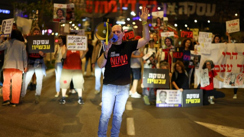 Demonstran menunjukkan tanda-tanda di tengah lalu lintas pada protes menuntut pembebasan sandera yang diculik dalam serangan mematikan 7 Oktober di Israel oleh kelompok Islam Palestina Hamas dari Gaza, di Tel Aviv, Israel 27 Maret 2024. (REUTERS/Hannah McKay)