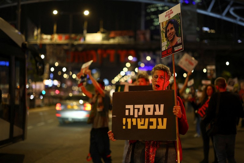 Demonstran menunjukkan tanda-tanda di tengah lalu lintas pada protes menuntut pembebasan sandera yang diculik dalam serangan mematikan 7 Oktober di Israel oleh kelompok Islam Palestina Hamas dari Gaza, di Tel Aviv, Israel 27 Maret 2024. (REUTERS/Hannah McKay)