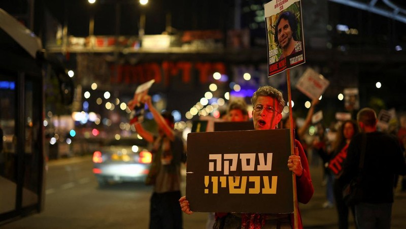 Demonstran menunjukkan tanda-tanda di tengah lalu lintas pada protes menuntut pembebasan sandera yang diculik dalam serangan mematikan 7 Oktober di Israel oleh kelompok Islam Palestina Hamas dari Gaza, di Tel Aviv, Israel 27 Maret 2024. (REUTERS/Hannah McKay)