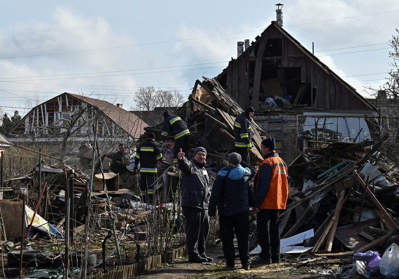UKRAINE-CRISIS/ATTACK-ZAPORIZHZHIA Rescuers work at the site of damaged residential buildings, next to a crater that appeared during a Russian drone strike, amid Russia's attack on Ukraine, in Zaporizhzhia, Ukraine March 28, 2024. REUTERS/Stringer