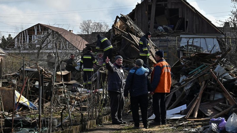 Rescuers work at the site of damaged residential buildings, next to a crater that appeared during a Russian drone strike, amid Russia's attack on Ukraine, in Zaporizhzhia, Ukraine March 28, 2024. REUTERS/Stringer