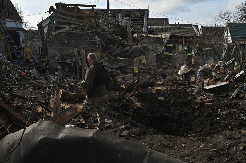Rescuers work at the site of damaged residential buildings, next to a crater that appeared during a Russian drone strike, amid Russia's attack on Ukraine, in Zaporizhzhia, Ukraine March 28, 2024. REUTERS/Stringer
