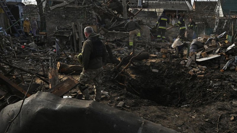 Rescuers work at the site of damaged residential buildings, next to a crater that appeared during a Russian drone strike, amid Russia's attack on Ukraine, in Zaporizhzhia, Ukraine March 28, 2024. REUTERS/Stringer
