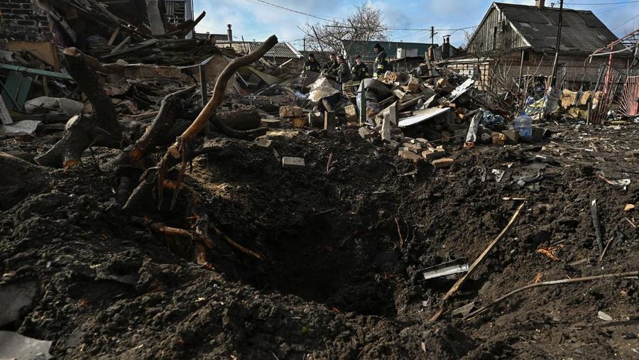 Rescuers work at the site of damaged residential buildings, next to a crater that appeared during a Russian drone strike, amid Russia's attack on Ukraine, in Zaporizhzhia, Ukraine March 28, 2024. REUTERS/Stringer