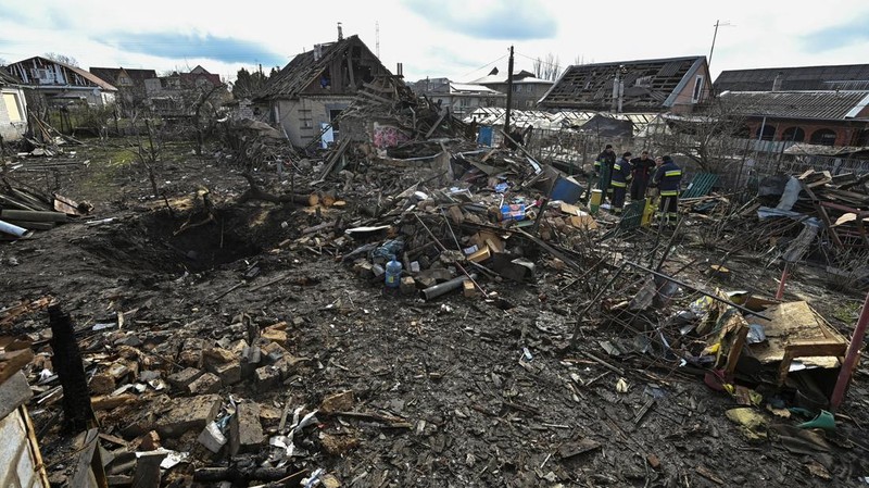 Rescuers work at the site of damaged residential buildings, next to a crater that appeared during a Russian drone strike, amid Russia's attack on Ukraine, in Zaporizhzhia, Ukraine March 28, 2024. REUTERS/Stringer
