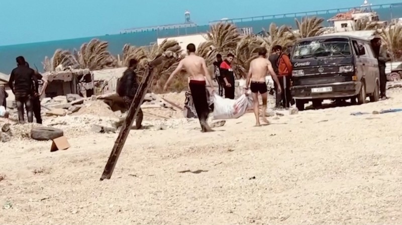 Warga Palestina bergegas menuju pantai untuk mengumpulkan bantuan yang dijatuhkan dari udara, di tengah konflik yang sedang berlangsung antara Israel dan Hamas, di Jalur Gaza utara, 25 Maret 2024. Warga Palestina bergegas menuju pantai untuk mengumpulkan bantuan yang dijatuhkan dari udara, di tengah konflik yang sedang berlangsung antara Israel dan Hamas, di Jalur Gaza utara, 25 Maret 2024. (REUTERS/Stringer)